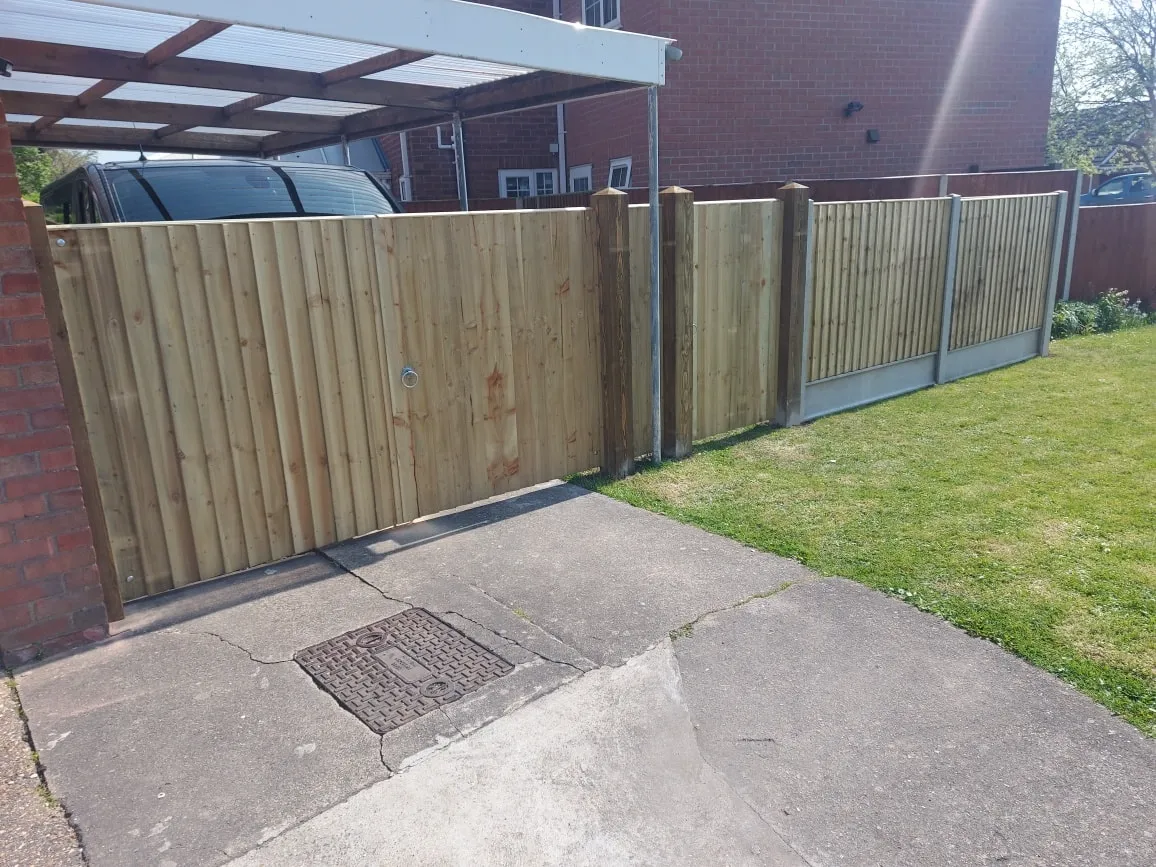 A wooden fence next to a brick building.